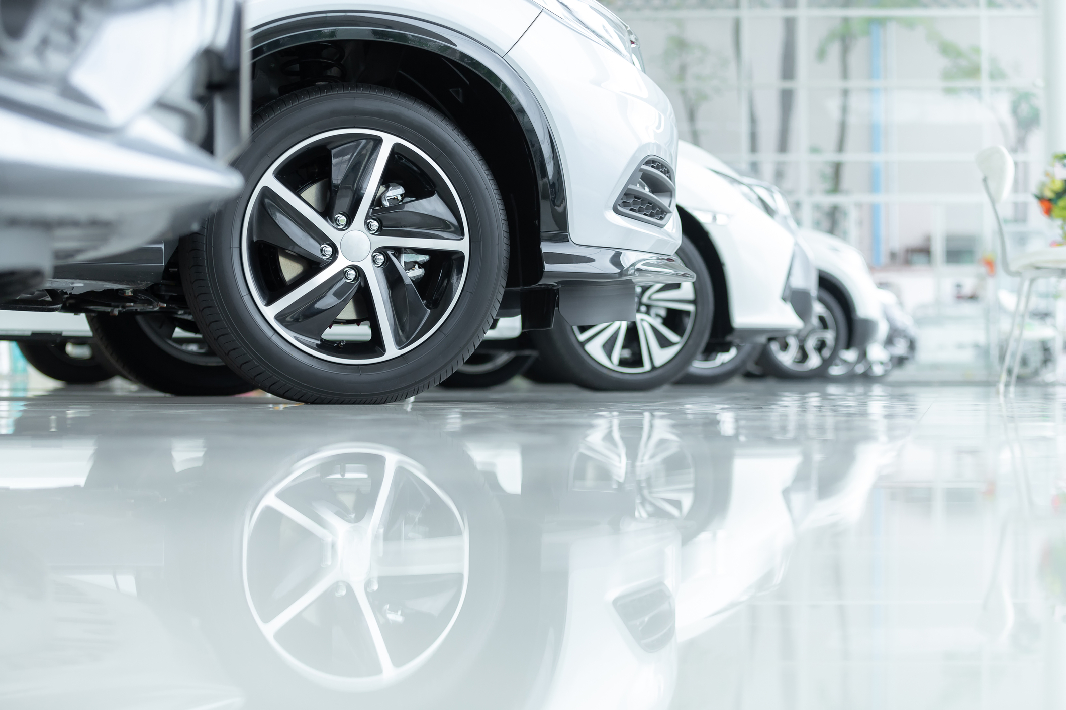 Carros à venda, Indústria automóvel, Parque de estacionamento de concessionários de automóveis. Filas de veículos novos à espera de novos proprietários, no chão de epóxi em serviço de carros novos.