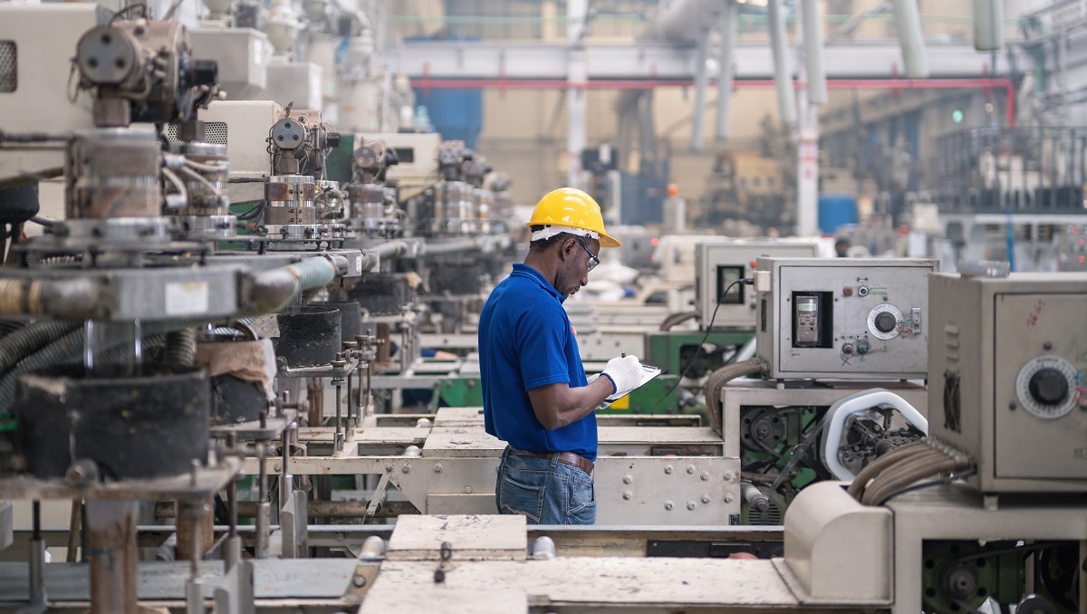 Un travailleur effectuant un examen du régime de sécurité des produits dans un entrepôt.