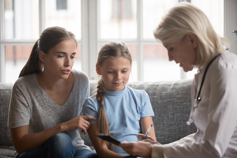 Um profissional de saúde a falar com uma mãe e uma filha.