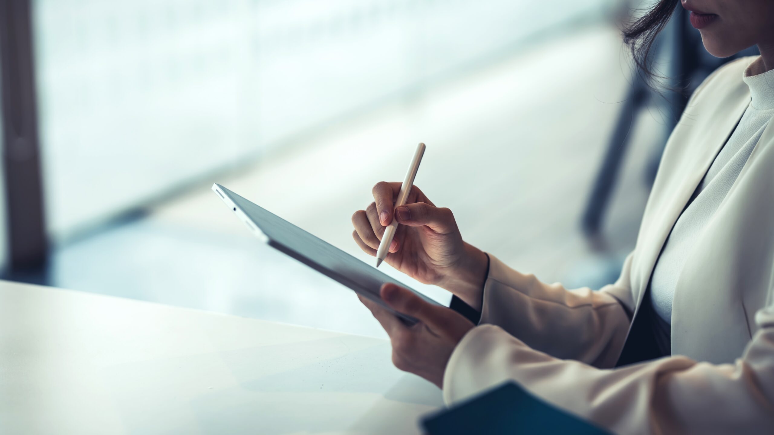 Un professionnel écrit sur une tablette.