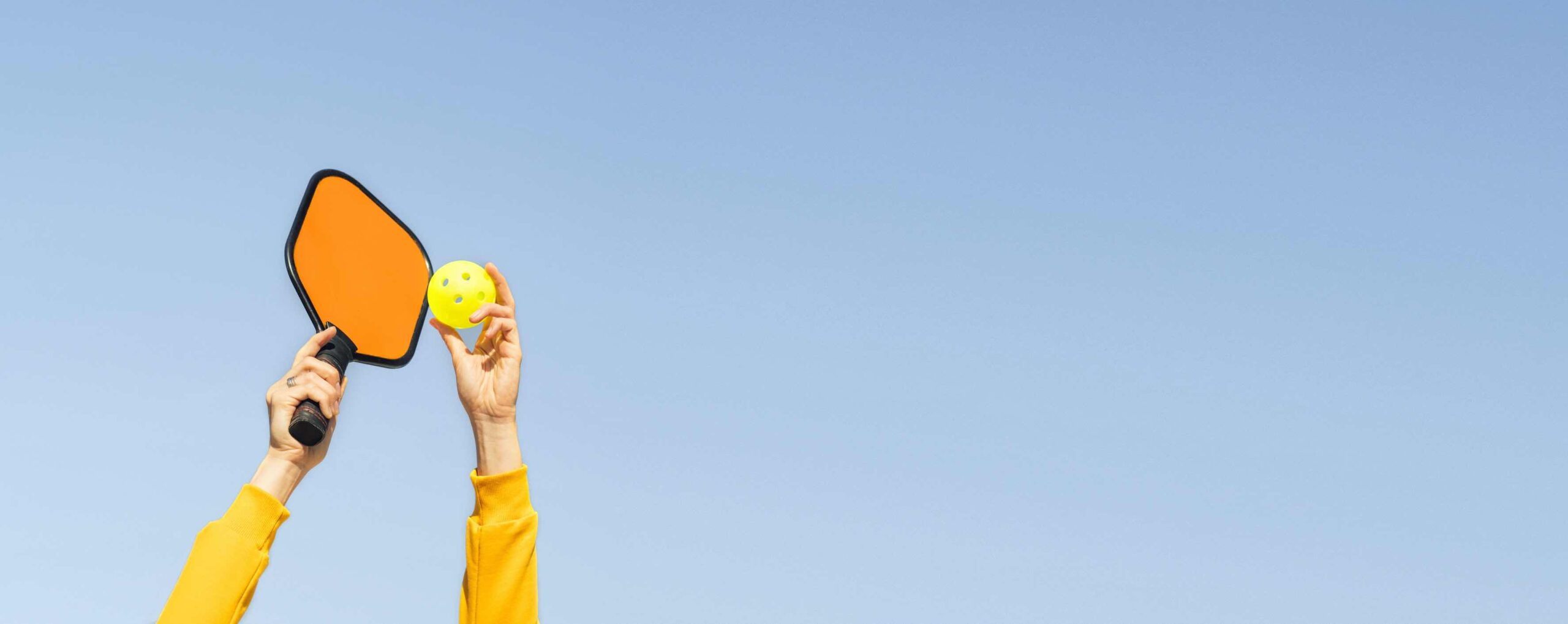 Quelqu’un qui fait un service overhand en pickleball.