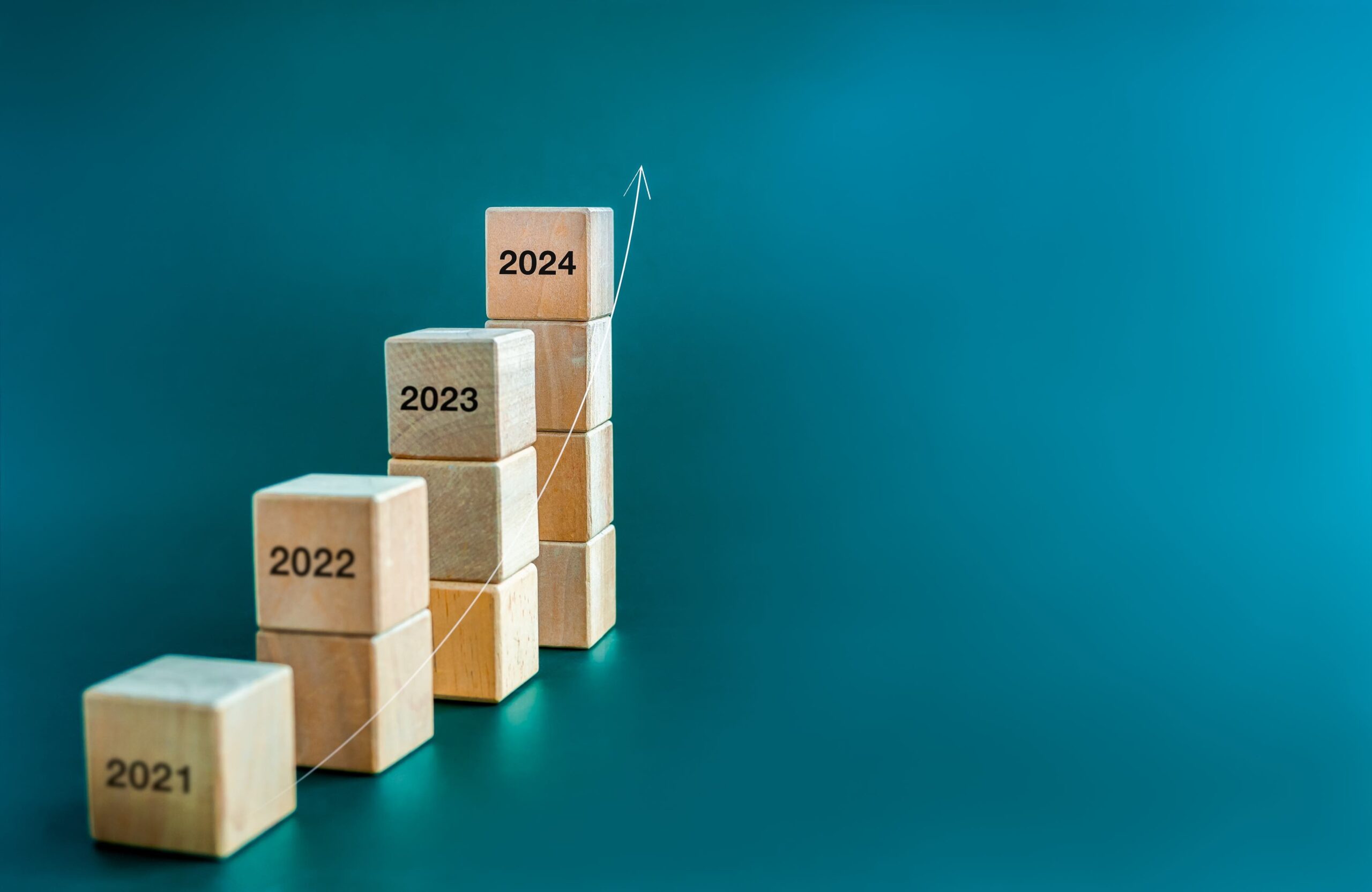 Kleine Stapel von Blöcken in ansteigender Höhe, auf denen die Jahreszahlen 2021-2024 eingraviert sind, um den Lauf der Zeit anzuzeigen.