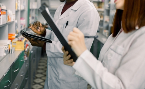 Pharmaciens enregistrant des données en laboratoire.