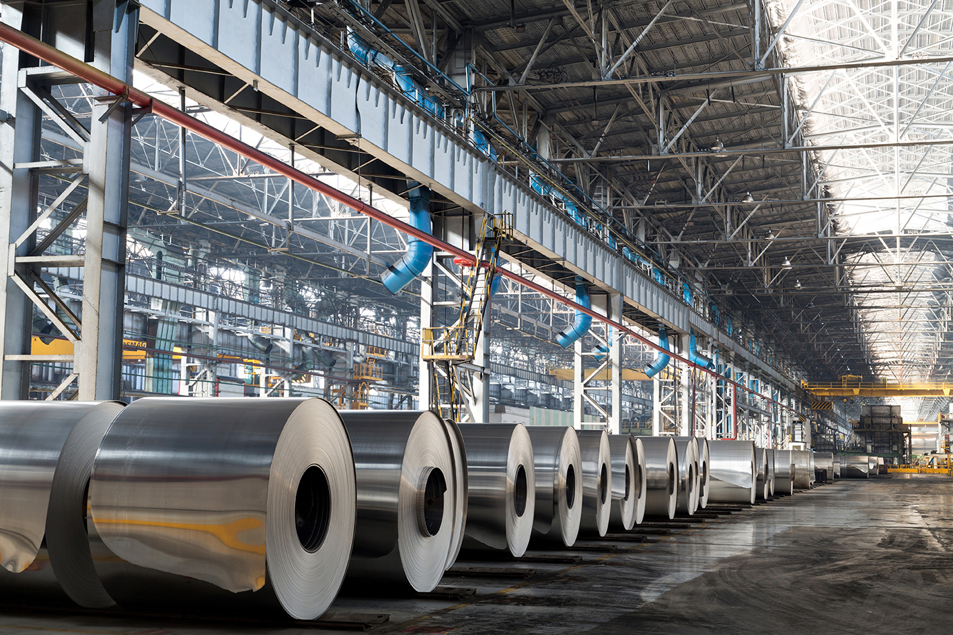 Long row of rolls of aluminum in a production shop of a plant.
